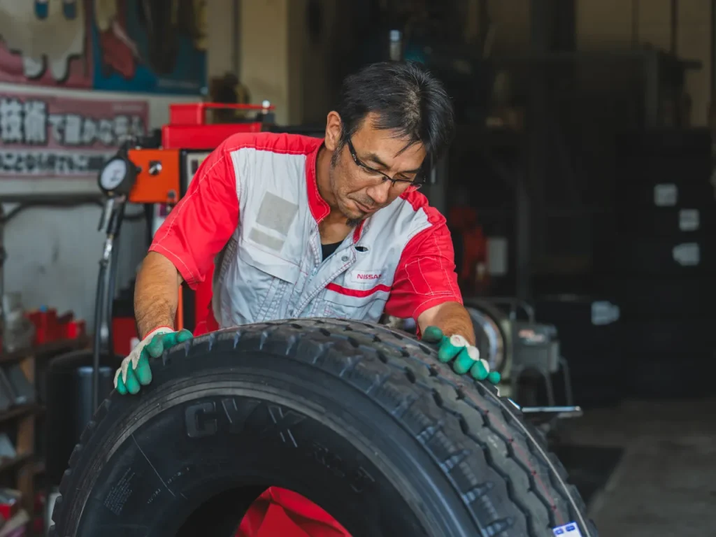 安全タイヤ（スタッフが大型車のタイヤの溝をチェックしている写真）