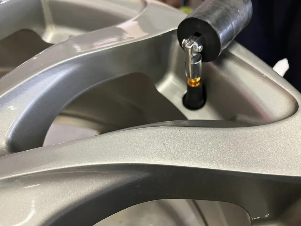 ホイールバルブをレンチで取り外す様子